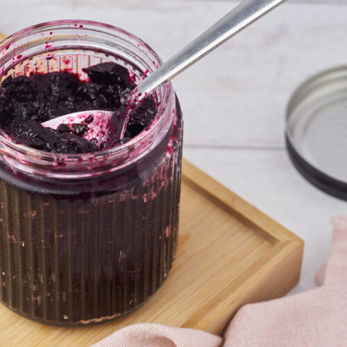 blueberry compote with a spoon in a jar.