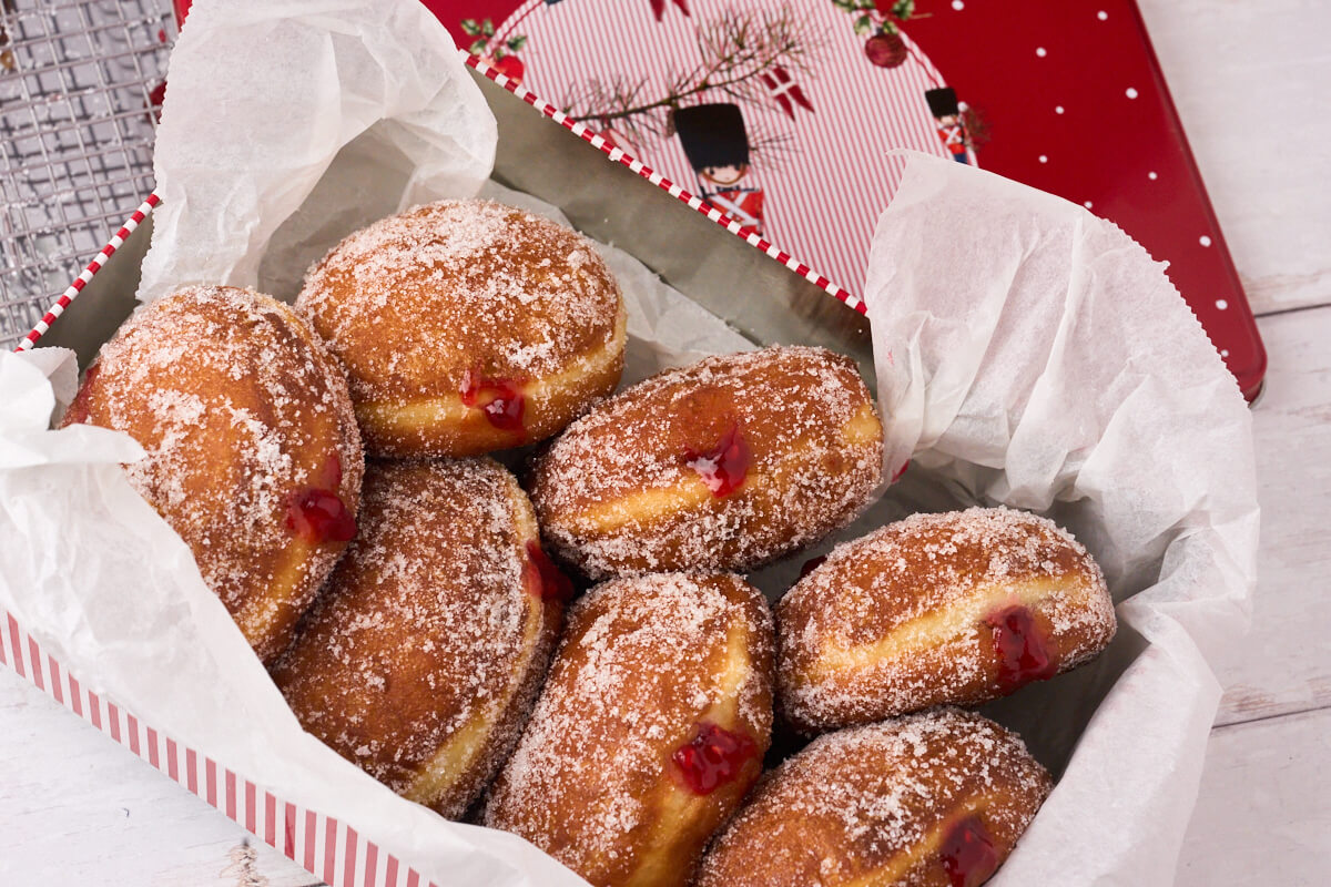 cake tin with freshly made berliner pfannkuchen with raspberry.