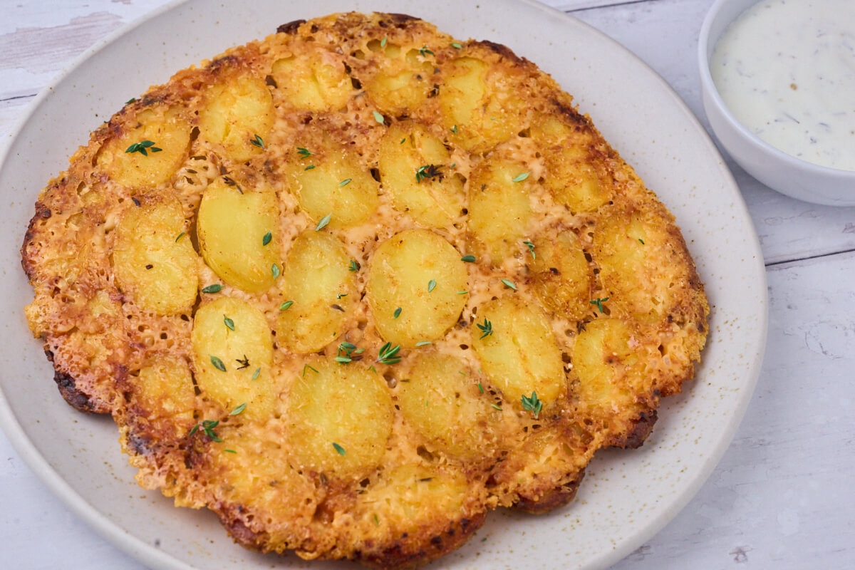 plate with crispy parmesan potatoes and dipping sauce.