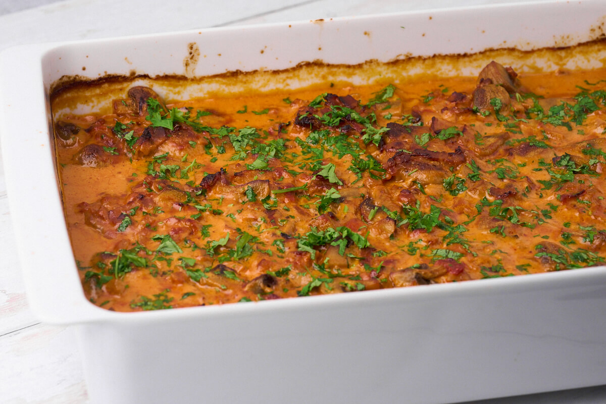 ovenproof dish with pork tenderloin in creamy mushroom sauce.